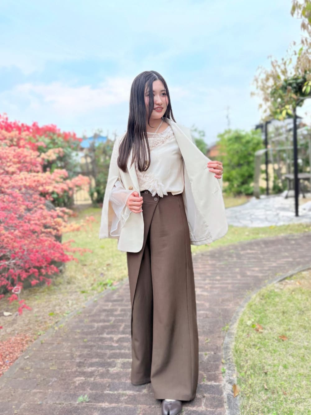 ベージュ系のテーラードジャケット、ベージュ系のシャツ/ブラウス、ブラウン系のパンツを着用したレディースの春コーディネートの2枚目の写真