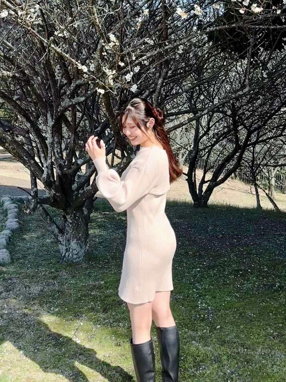 ベージュ系のワンピース、ブラック系のブーツを着用したレディースの春コーディネートの2枚目の写真
