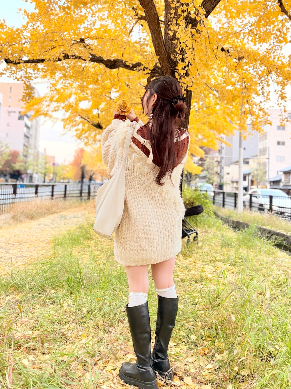 ベージュ系のニット/セーター、オレンジ系のTシャツ/カットソー、ブラック系のブーツを着用したレディースの秋コーディネートの3枚目の写真