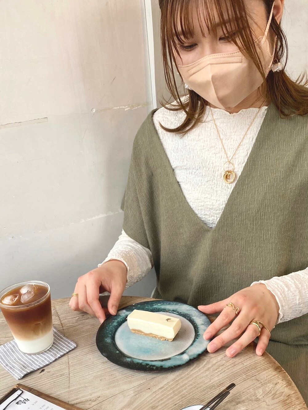 グリーン系のベスト、ホワイト系のTシャツ/カットソー、グリーン系のスカートを着用したレディースの春コーディネートの4枚目の写真