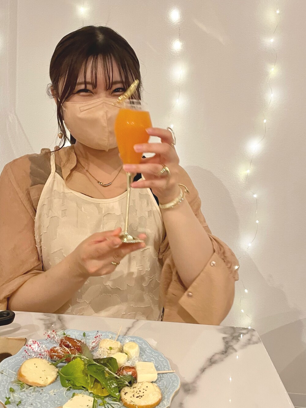 オレンジ系のシャツ/ブラウス、ベージュ系のワンピース、ホワイト系のワンピースを着用したレディースの夏コーディネートの3枚目の写真