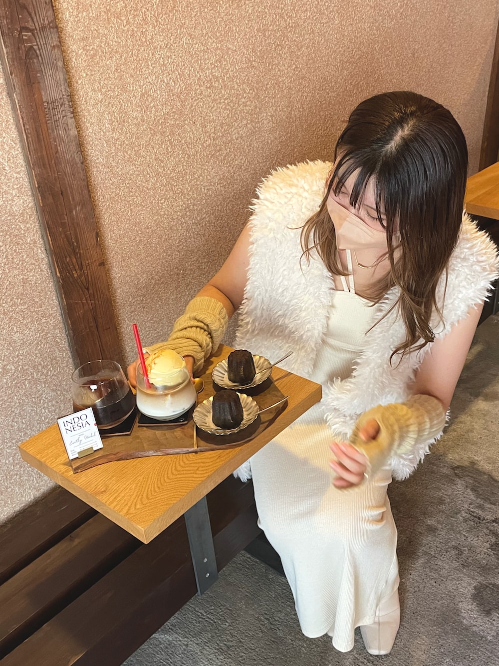 ホワイト系のワンピース、ベージュ系のショルダーバッグ、ホワイト系のブーツを着用したレディースの秋コーディネートの4枚目の写真