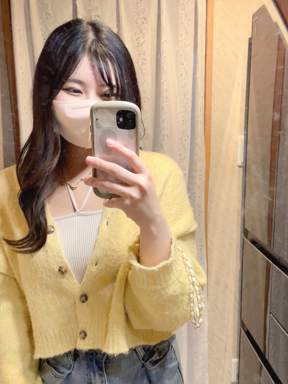 ベージュ系のキャミソール、ブルー系のデニムパンツを着用したレディースの春コーディネートの3枚目の写真