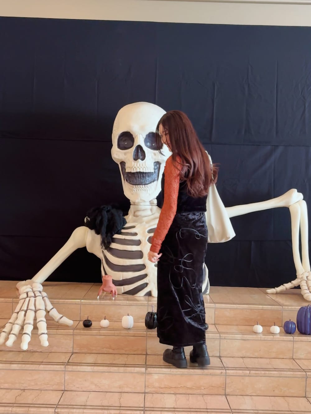 オレンジ系のTシャツ/カットソー、ブラック系のスカート、ホワイト系のトートバッグを着用したレディースの秋コーディネートの3枚目の写真