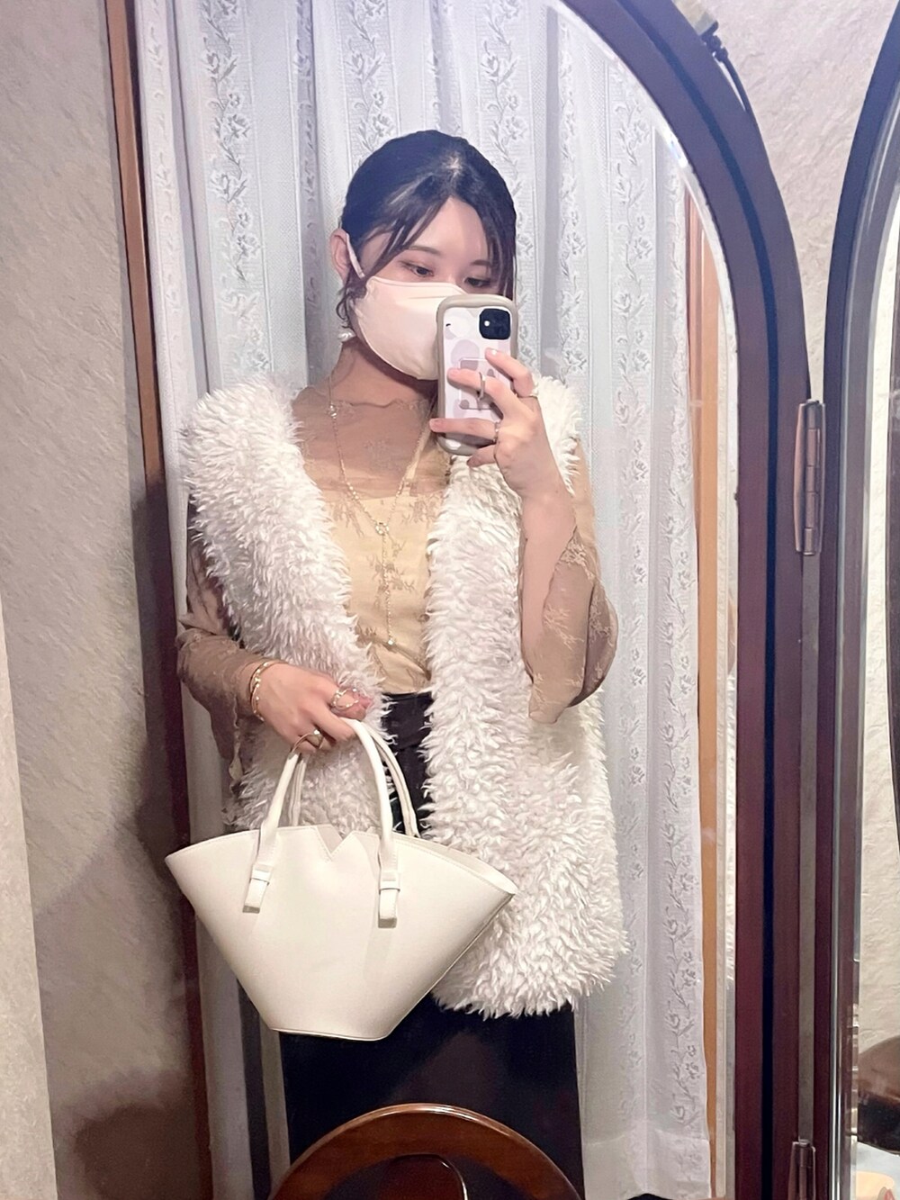 ベージュ系のシャツ/ブラウス、ホワイト系のベスト、ベージュ系のキャミソールを着用したレディースの秋コーディネートの2枚目の写真