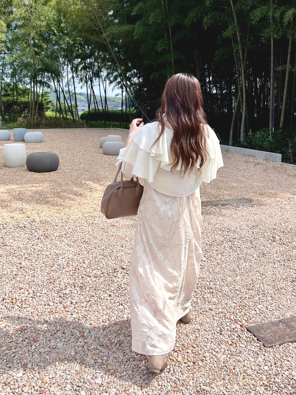 ホワイト系のカーディガン/ボレロ、ベージュ系のワンピース、ゴールド系のネックレスを着用したレディースの秋コーディネートの4枚目の写真