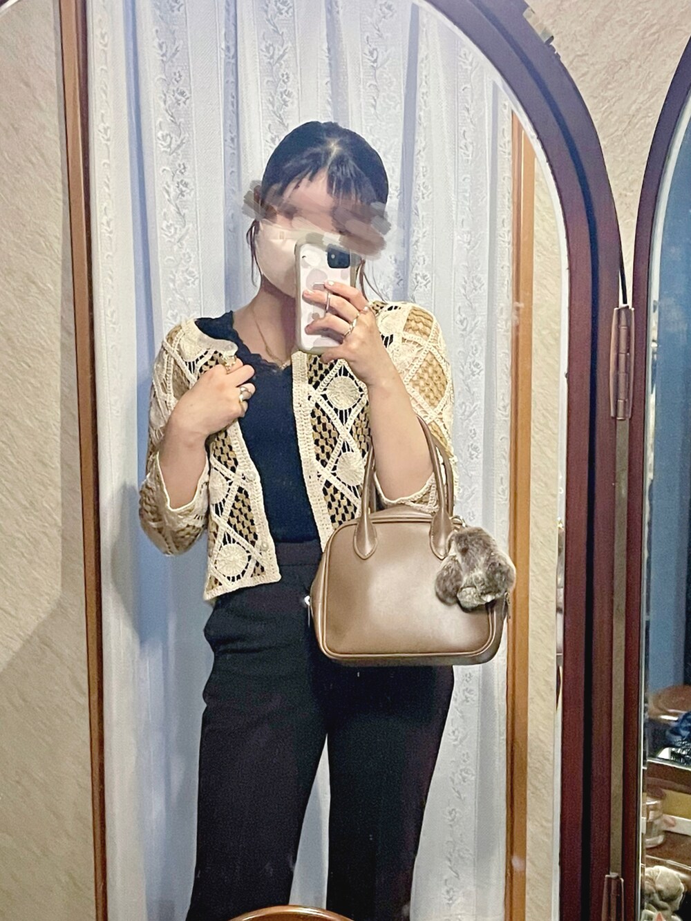 イエロー系のニット/セーター、ブラック系のタンクトップ、ベージュ系のショルダーバッグを着用したレディースの秋コーディネートの2枚目の写真