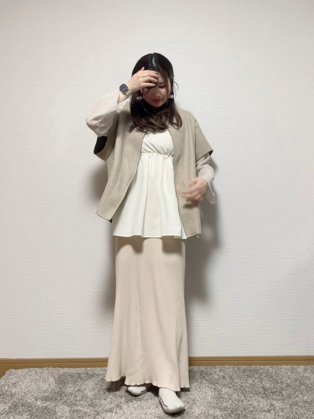 ベージュ系のトップス、ベージュ系のスカート、ベージュ系のタンクトップを着用したレディースの春コーディネートの2枚目の写真