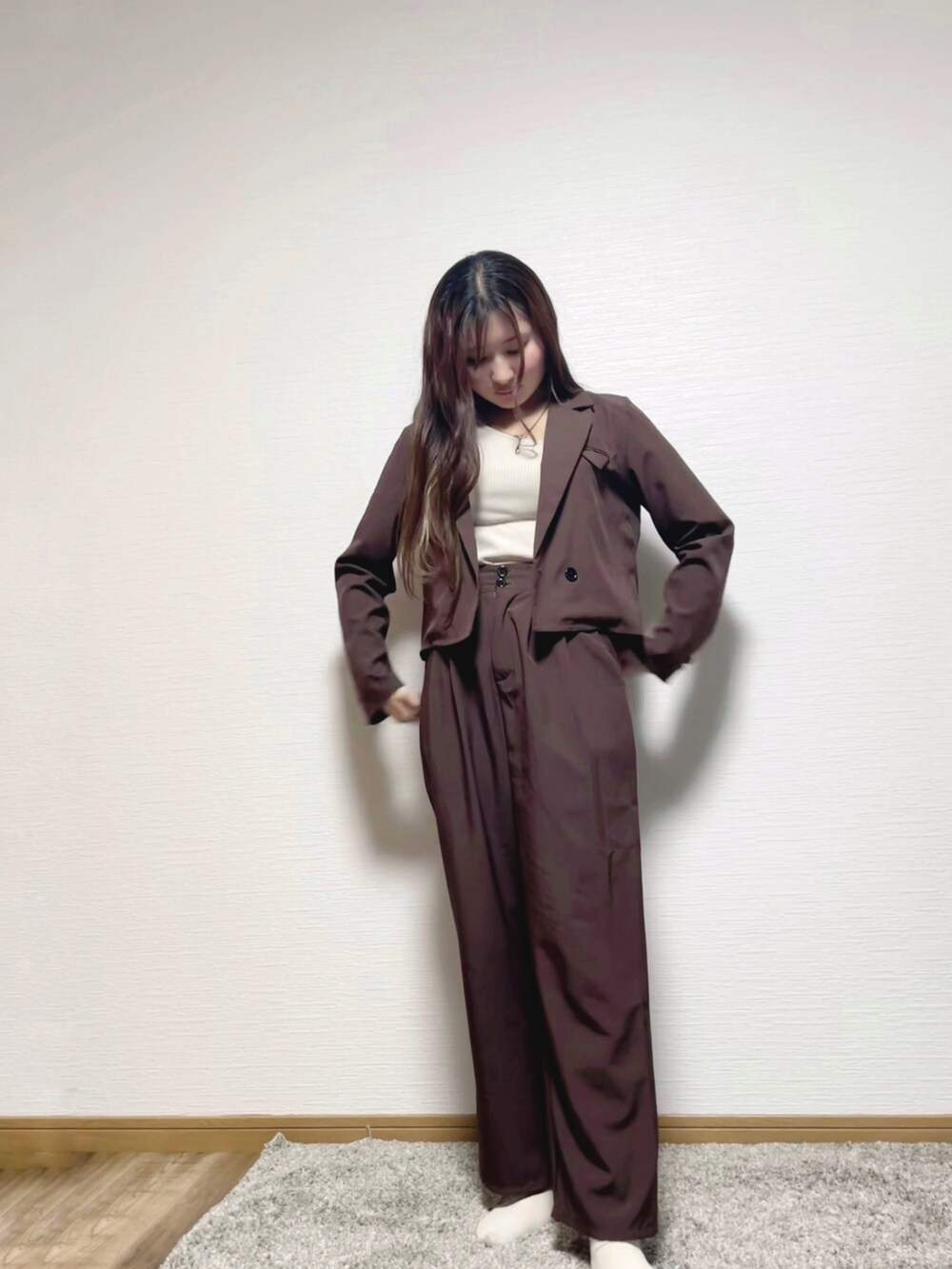 ブラウン系のテーラードジャケット、ベージュ系のタンクトップ、ゴールド系のネックレスを着用したレディースの秋コーディネートの2枚目の写真