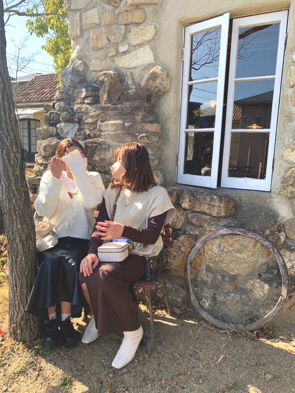 ベージュ系のベスト、ブラウン系のワンピース、ホワイト系のブーツを着用したレディースの春コーディネートの3枚目の写真