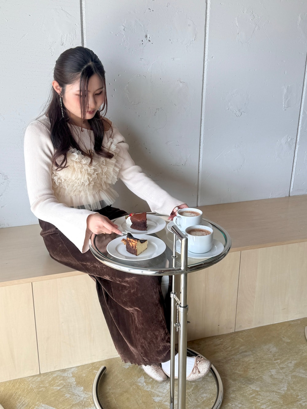 ホワイト系のニット/セーター、ベージュ系のキャミソール、ブラウン系のスカートを着用したレディースの冬コーディネートの3枚目の写真