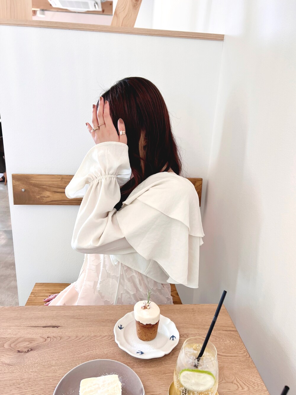 ホワイト系のカーディガン/ボレロ、ベージュ系のワンピース、ゴールド系のネックレスを着用したレディースの秋コーディネートの5枚目の写真