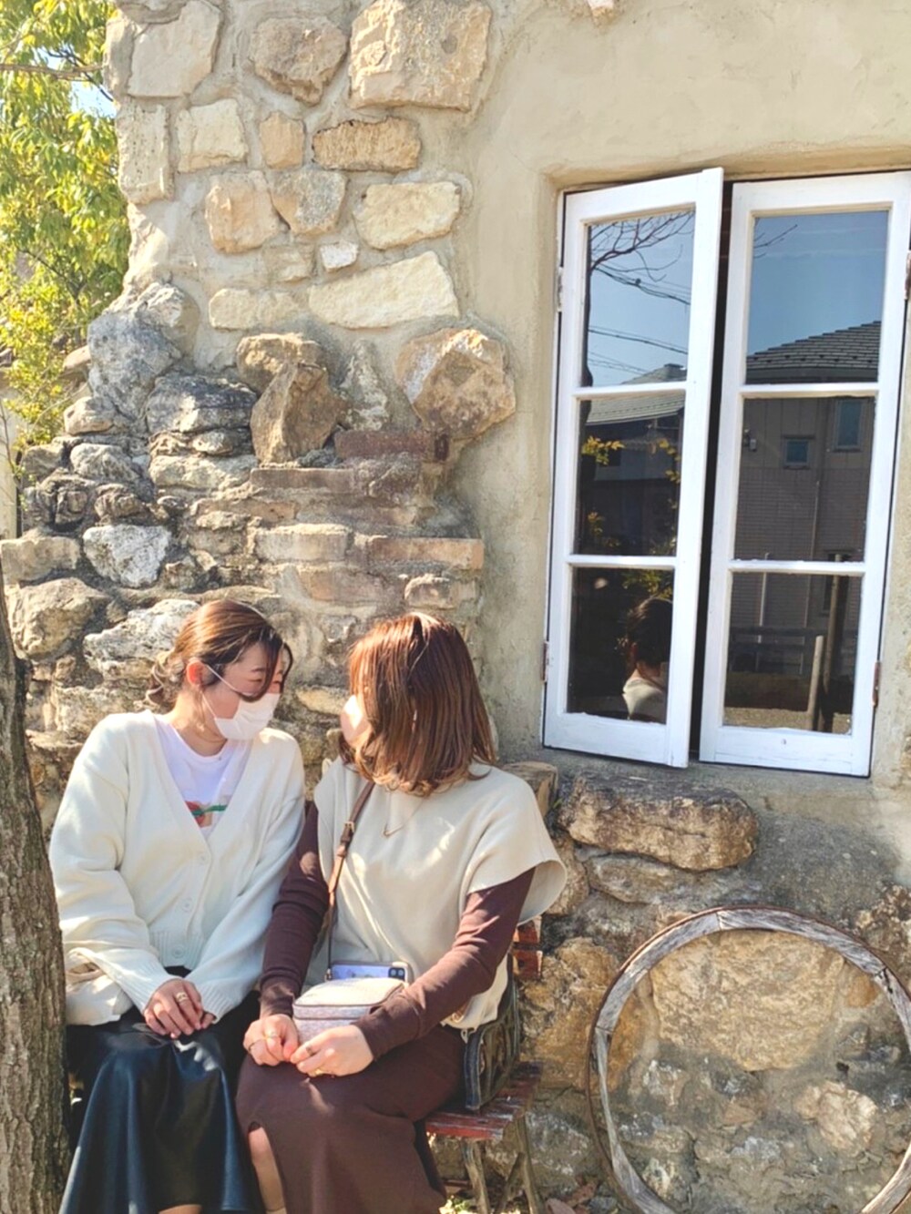 ベージュ系のベスト、ブラウン系のワンピース、ホワイト系のブーツを着用したレディースの春コーディネートの2枚目の写真