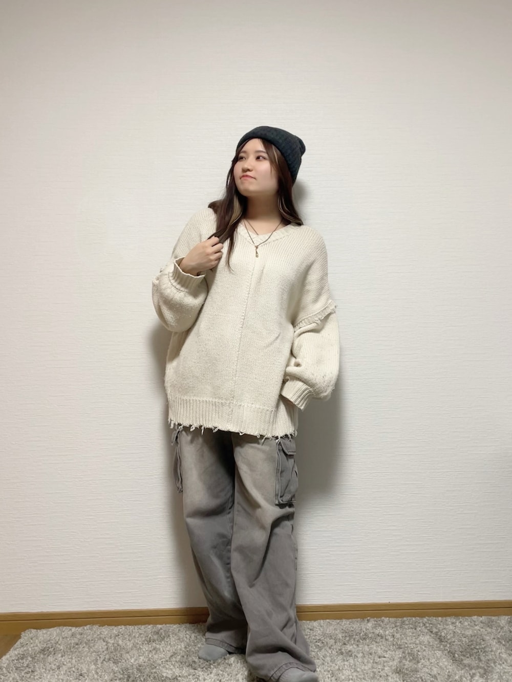 ホワイト系のニット/セーター、グレー系のデニムパンツ、ホワイト系のスニーカーを着用したレディースの秋コーディネートの2枚目の写真