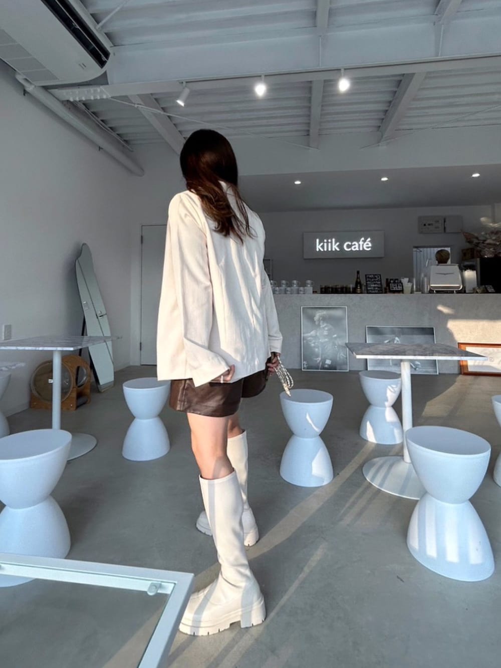 ホワイト系のセットアップ、ブラウン系のTシャツ/カットソー、ホワイト系のブーツを着用したレディースの秋コーディネートの4枚目の写真