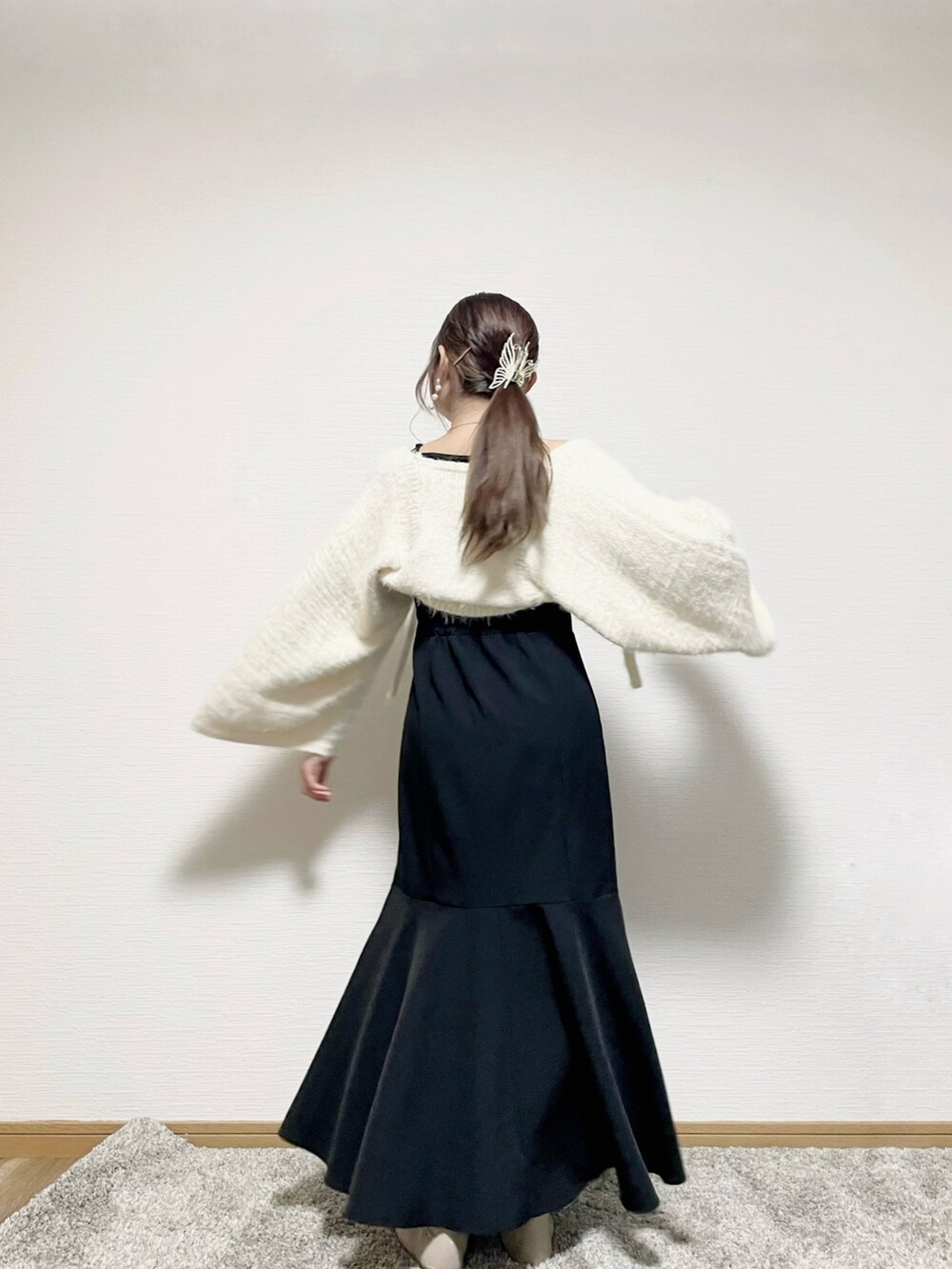 ブラック系のワンピース、ホワイト系のニット/セーターを着用したレディースの秋コーディネートの3枚目の写真