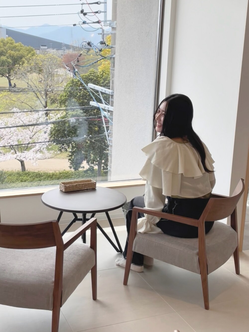 ホワイト系のカーディガン/ボレロ、ブラック系のデニムパンツ、グリーン系のニット/セーターを着用したレディースの春コーディネートの4枚目の写真