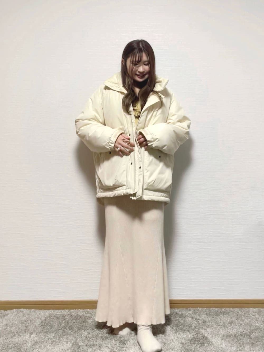 ベージュ系のタンクトップ、ホワイト系のショルダーバッグ、ベージュ系のスカートを着用したレディースの冬コーディネートの3枚目の写真