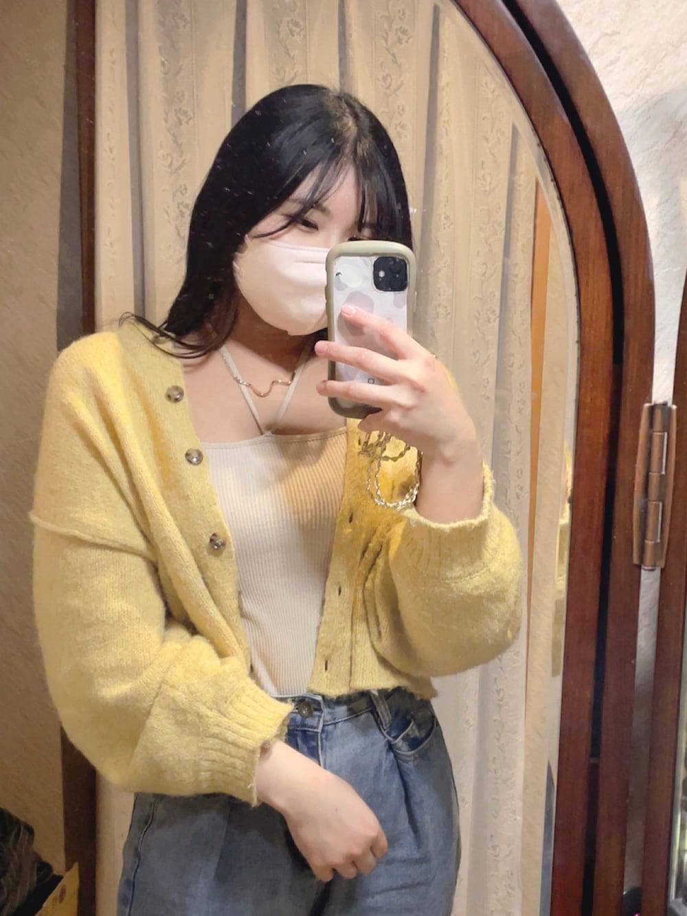 ベージュ系のキャミソール、ブルー系のデニムパンツを着用したレディースの春コーディネートの2枚目の写真