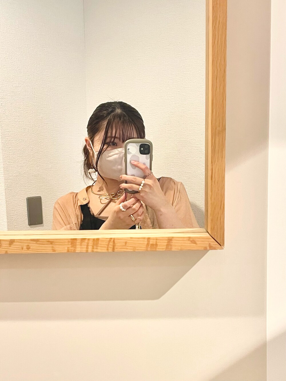 オレンジ系のシャツ/ブラウス、ブラック系のワンピース、ベージュ系のキャミソールを着用したレディースの春コーディネートの4枚目の写真