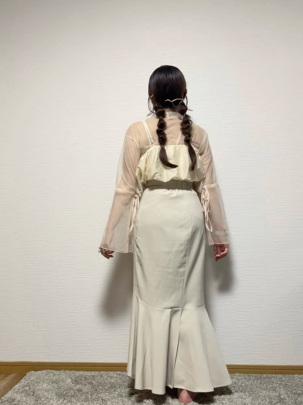 ホワイト系のTシャツ/カットソー、ベージュ系のベスト、ホワイト系のスカートを着用したレディースの秋コーディネートの3枚目の写真