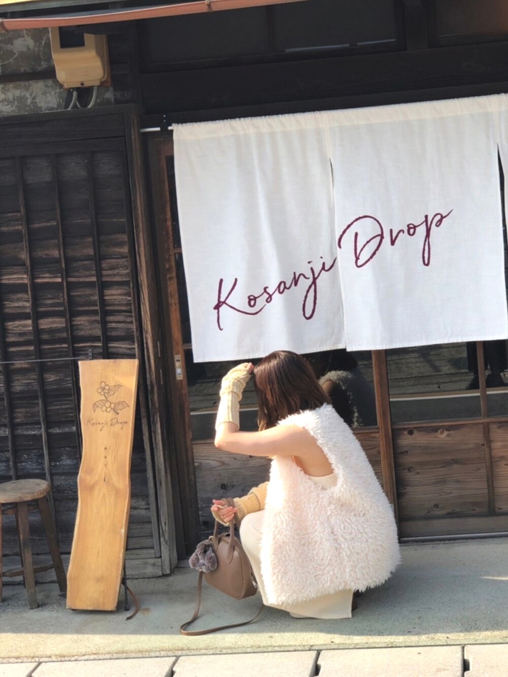 ホワイト系のワンピース、ベージュ系のショルダーバッグ、ホワイト系のブーツを着用したレディースの秋コーディネートの5枚目の写真