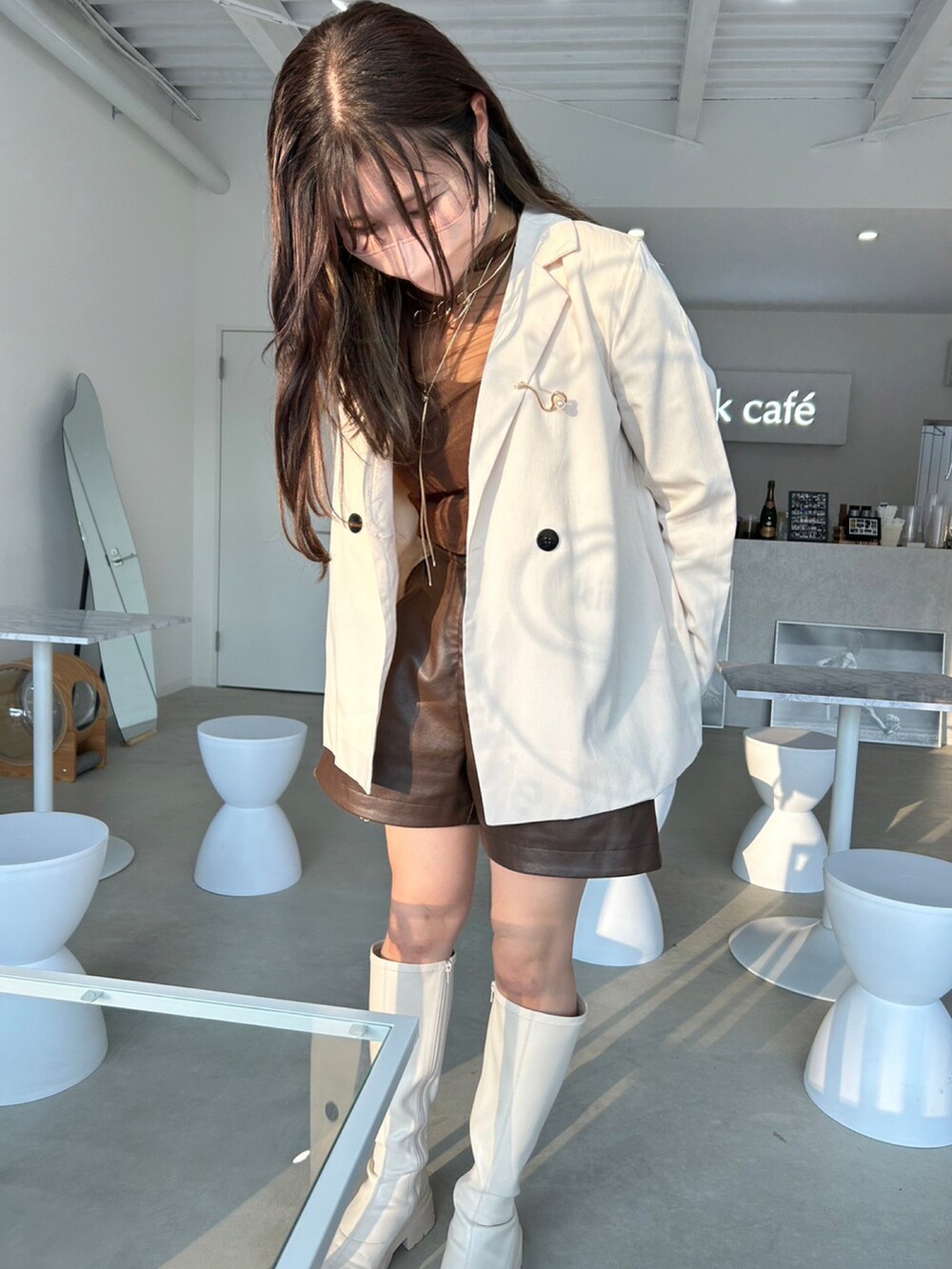 ホワイト系のセットアップ、ブラウン系のTシャツ/カットソー、ホワイト系のブーツを着用したレディースの秋コーディネートの3枚目の写真