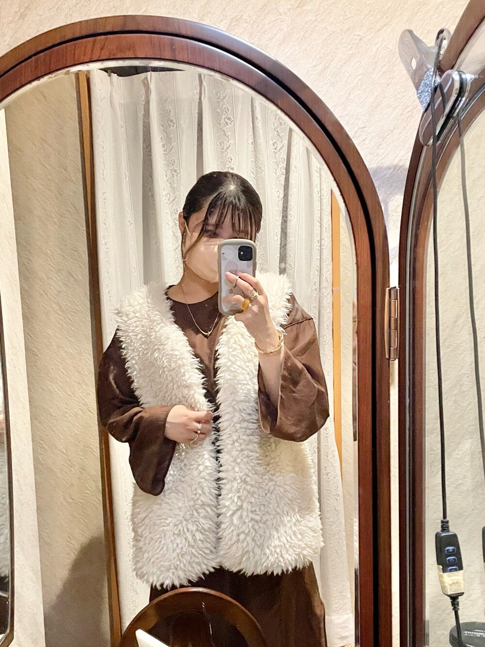 ブラウン系のワンピース、ホワイト系のベスト、ブラック系のキャミソールを着用したレディースの秋コーディネートの3枚目の写真