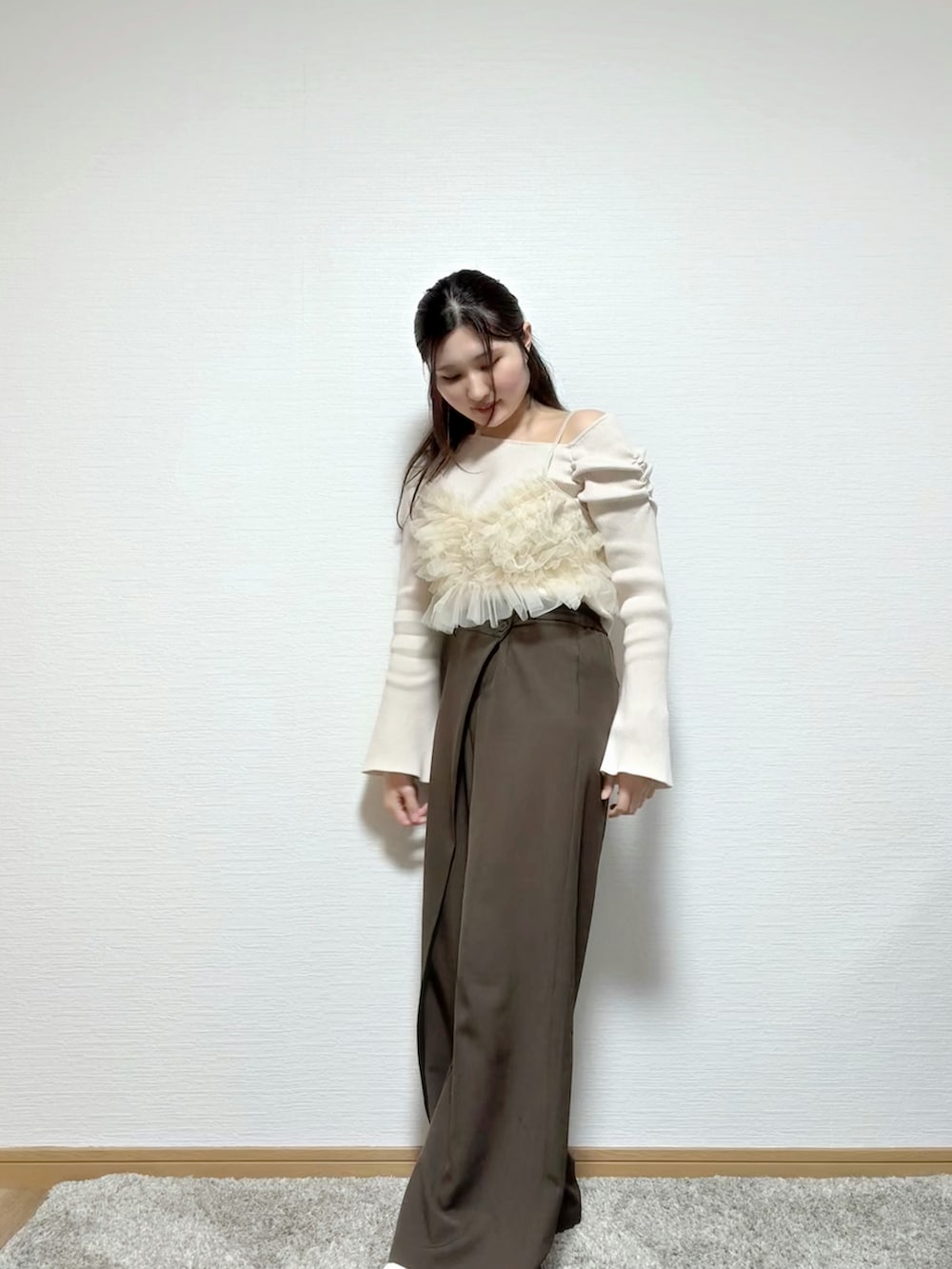 ベージュ系のキャミソール、ホワイト系のニット/セーター、ブラウン系のパンツを着用したレディースの春コーディネートの5枚目の写真