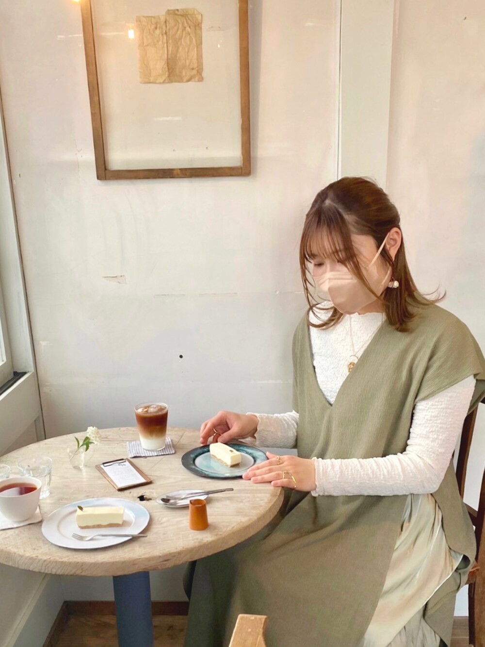 グリーン系のベスト、ホワイト系のTシャツ/カットソー、グリーン系のスカートを着用したレディースの春コーディネートの3枚目の写真