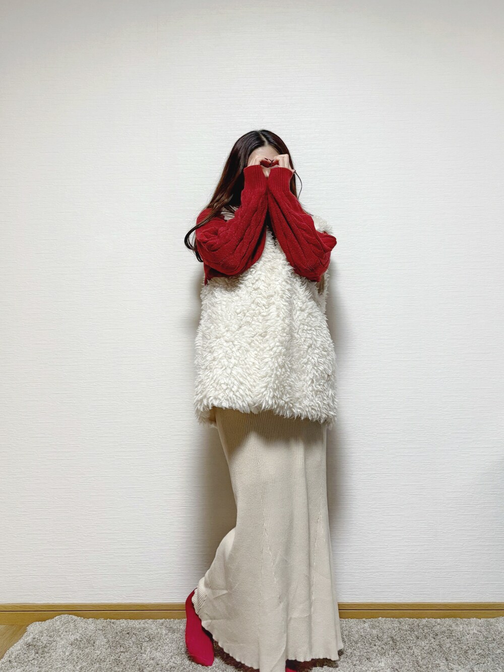 ホワイト系のベスト、ベージュ系のスカートを着用したレディースの冬コーディネートの3枚目の写真