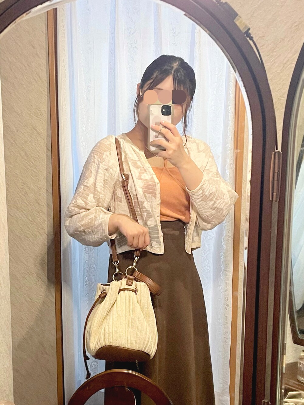 ホワイト系のノーカラージャケット、オレンジ系のキャミソール、ブラウン系のスカートを着用したレディースの秋コーディネートの3枚目の写真