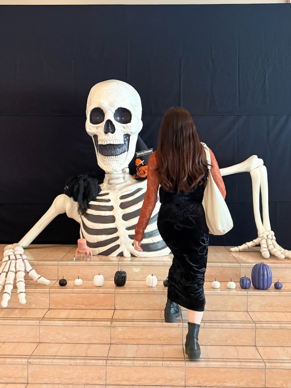 オレンジ系のTシャツ/カットソー、ブラック系のスカート、ホワイト系のトートバッグを着用したレディースの秋コーディネートの2枚目の写真