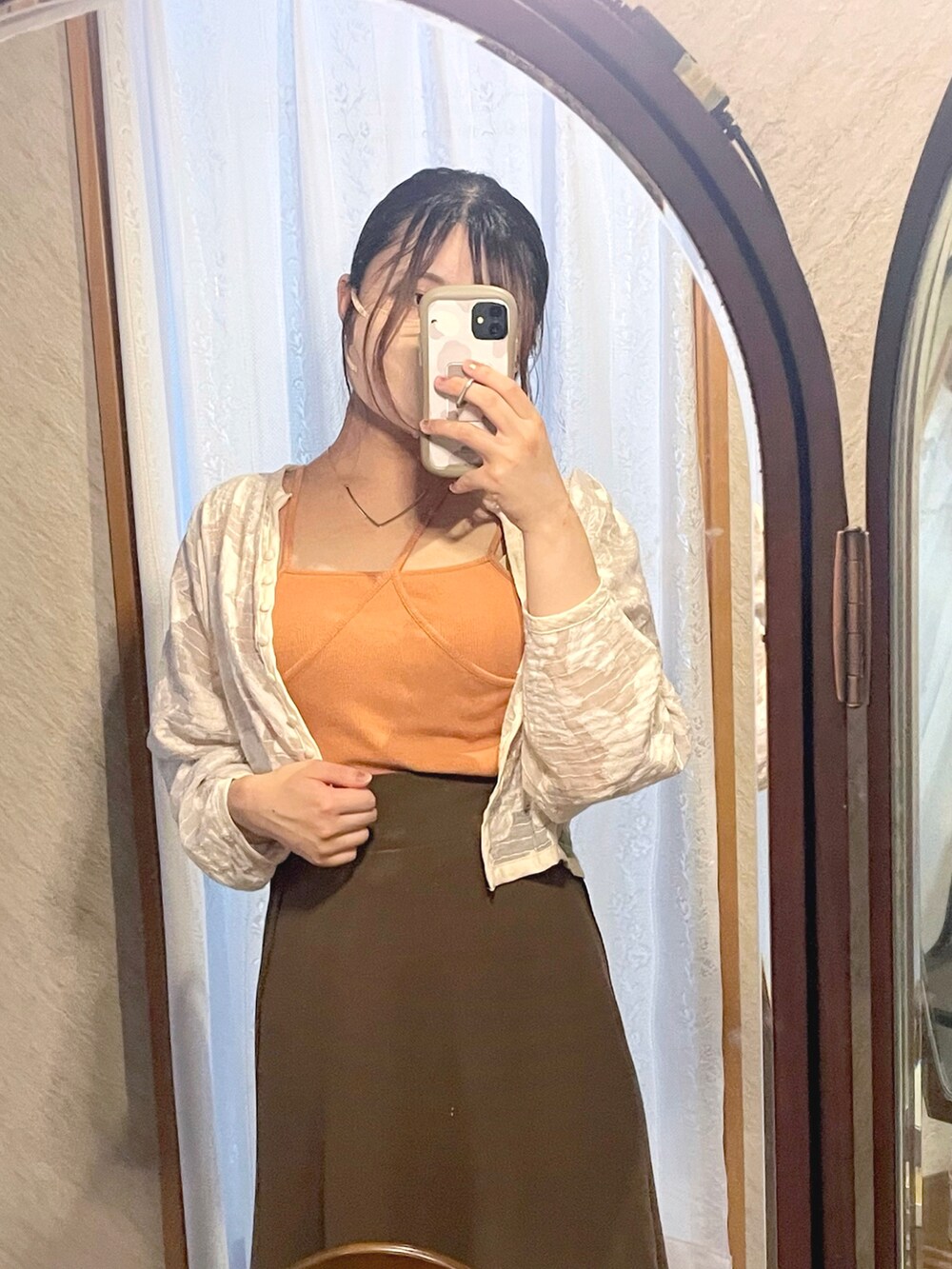 ホワイト系のノーカラージャケット、オレンジ系のキャミソール、ブラウン系のスカートを着用したレディースの秋コーディネートの4枚目の写真