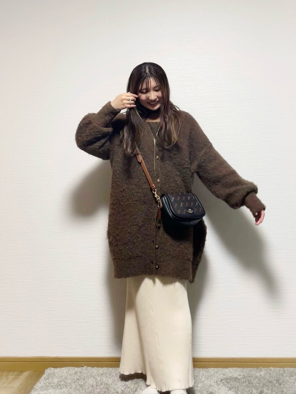 ブラウン系のTシャツ/カットソー、ブラウン系のチュニック、ベージュ系のスカートを着用したレディースの秋コーディネートの2枚目の写真