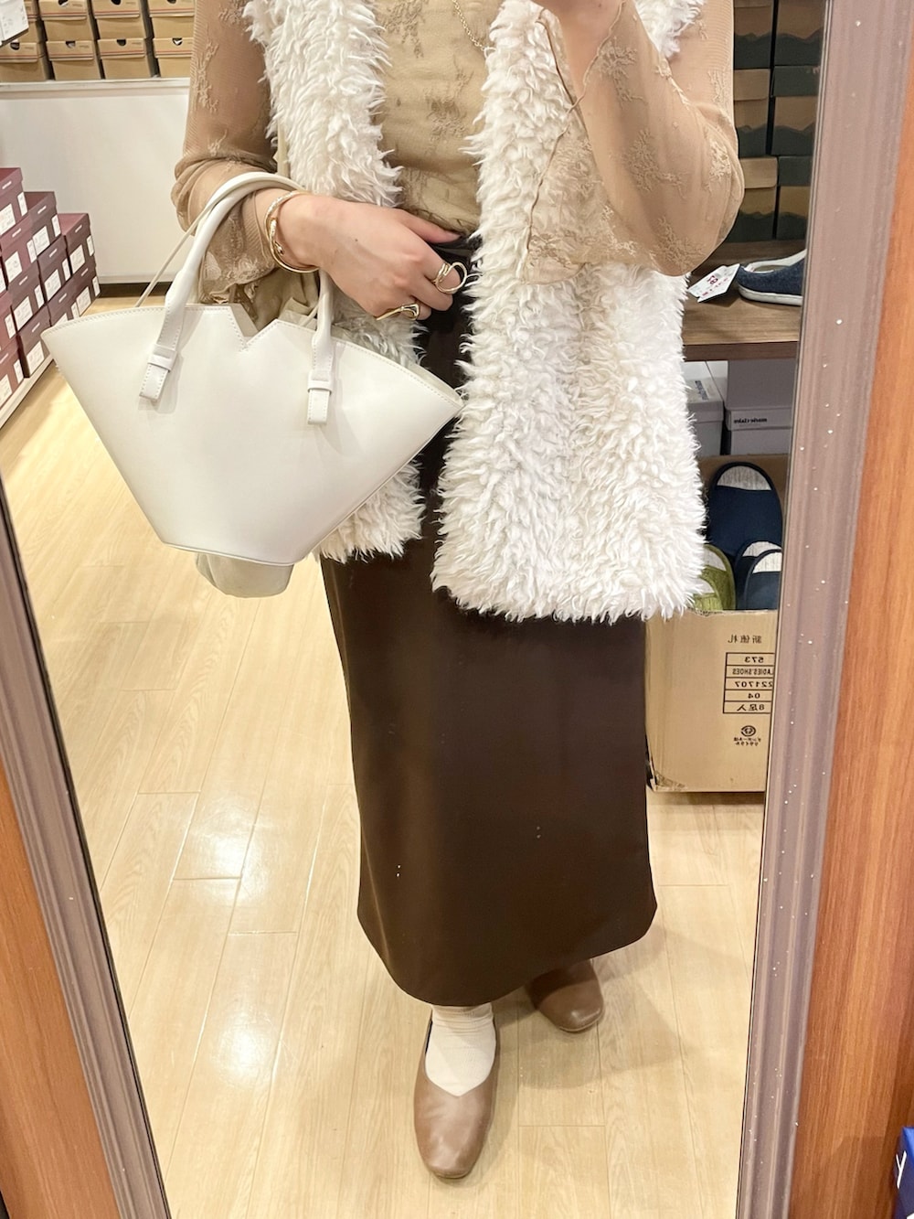 ベージュ系のシャツ/ブラウス、ホワイト系のベスト、ベージュ系のキャミソールを着用したレディースの秋コーディネートの4枚目の写真