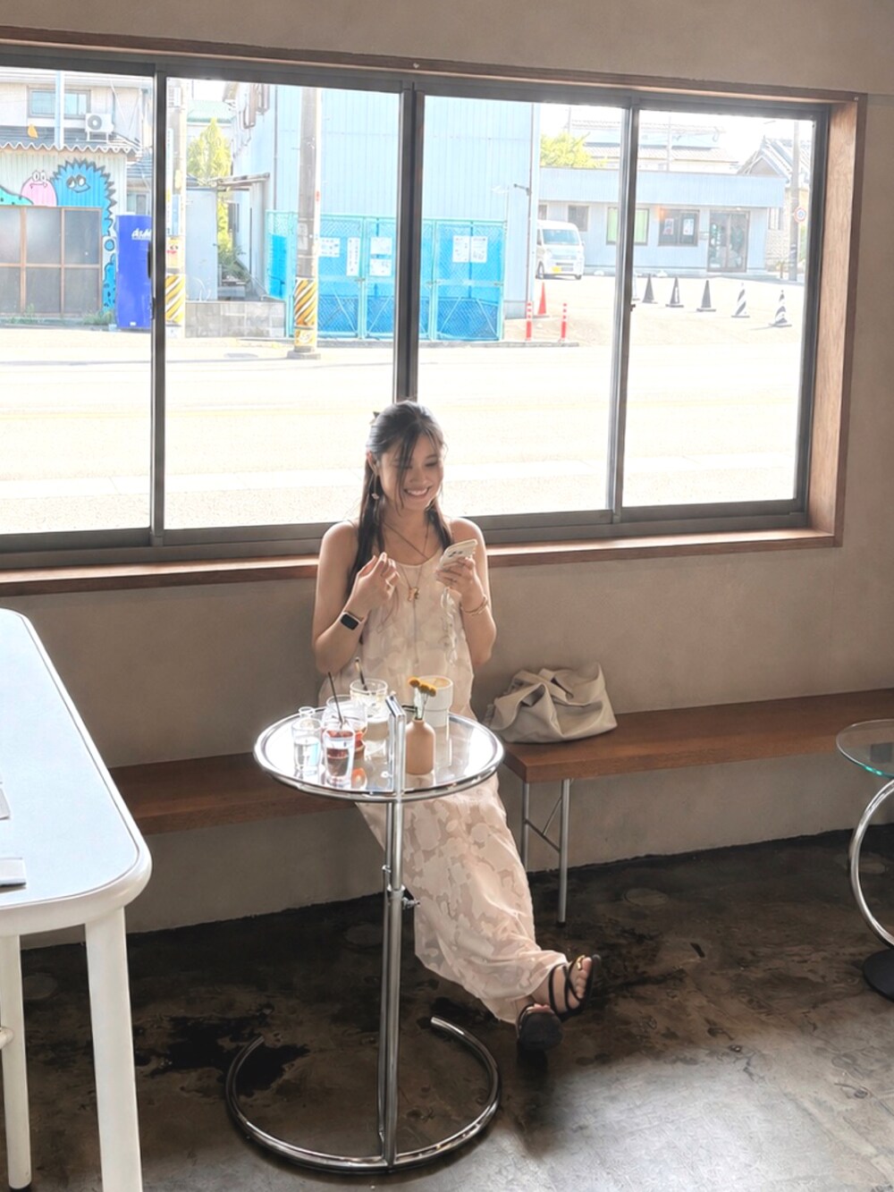 ベージュ系のワンピース、ブラウン系のキャミソール、ブラウン系のサンダルを着用したレディースの秋コーディネートの2枚目の写真