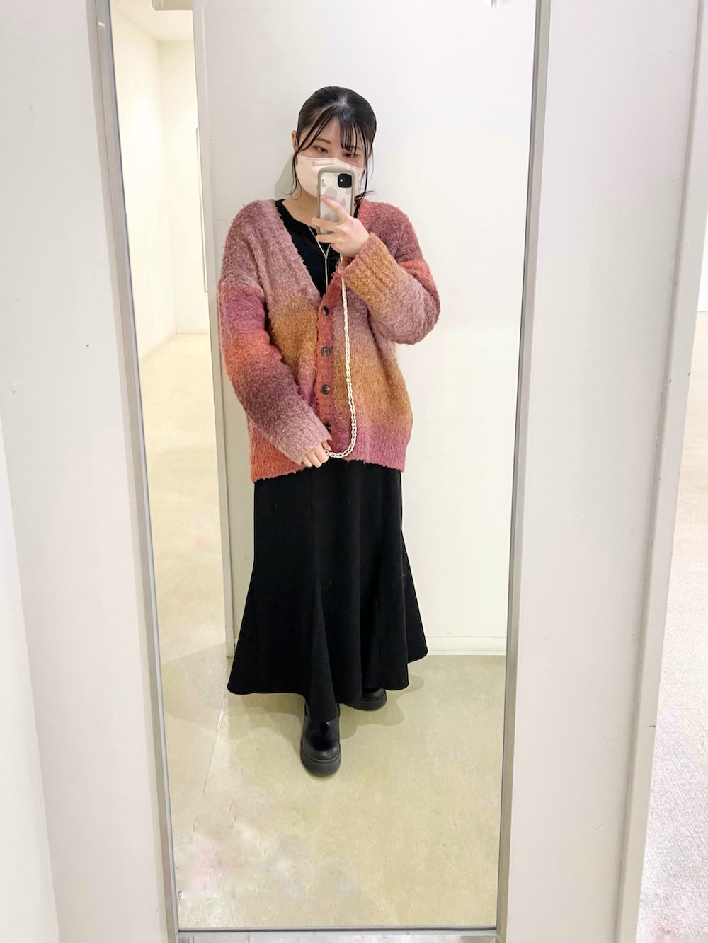 ピンク系のカーディガン/ボレロ、ブラック系のニット/セーター、ブラック系のスカートを着用したレディースの冬コーディネートの2枚目の写真