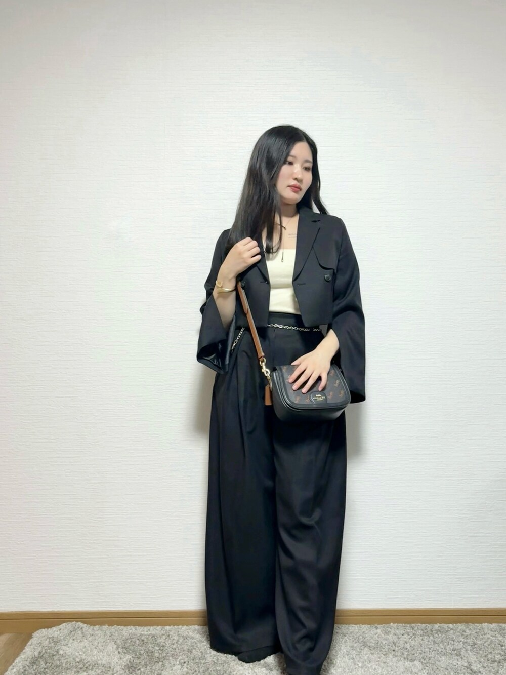 グレー系のテーラードジャケット、ブラック系のスラックス、ベージュ系のキャミソールを着用したレディースの秋コーディネートの2枚目の写真