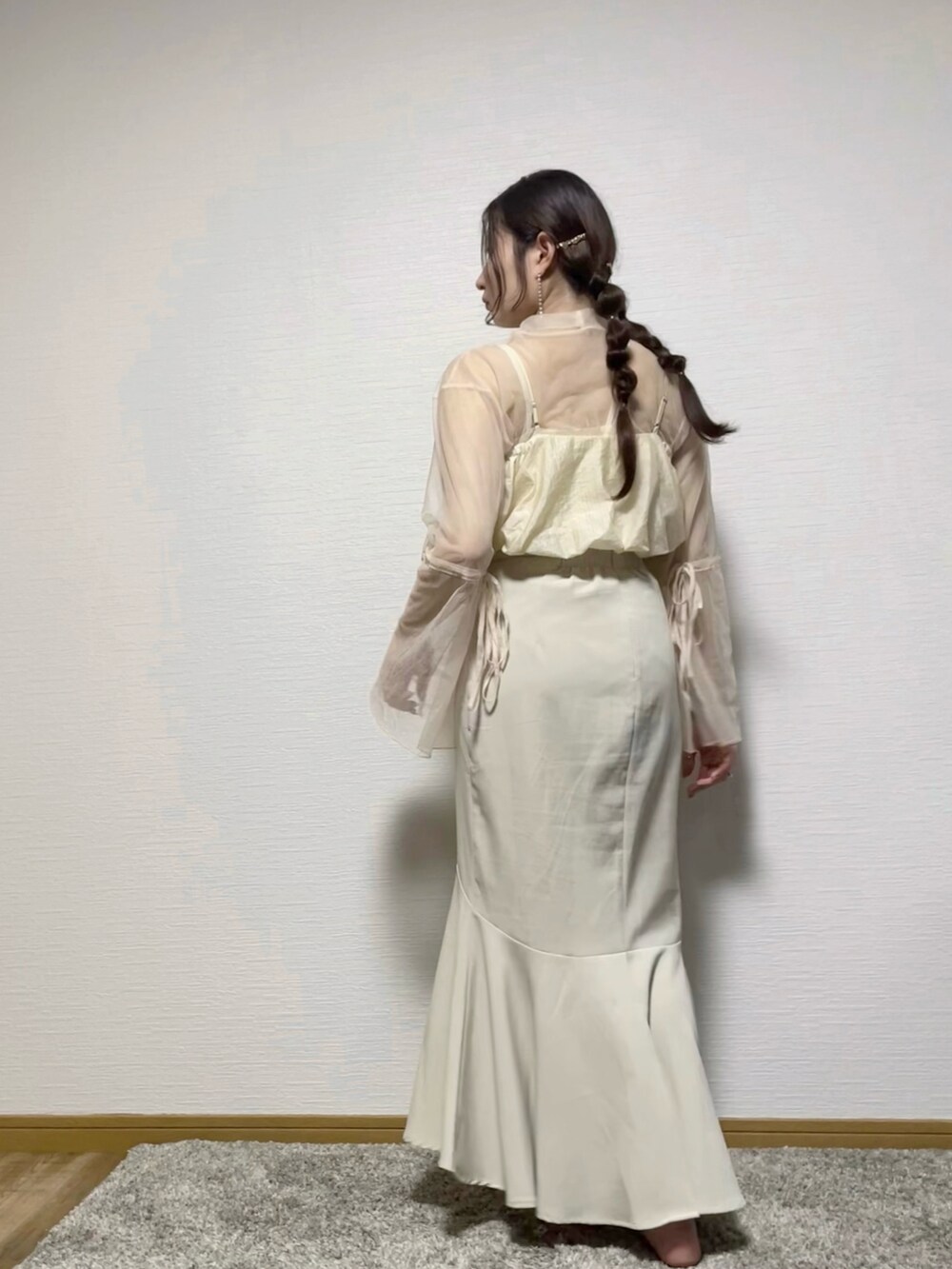 ホワイト系のTシャツ/カットソー、ベージュ系のベスト、ホワイト系のスカートを着用したレディースの秋コーディネートの2枚目の写真