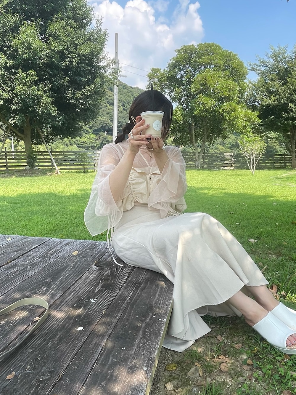 ホワイト系のTシャツ/カットソー、ベージュ系のベスト、ホワイト系のスカートを着用したレディースの秋コーディネートの4枚目の写真