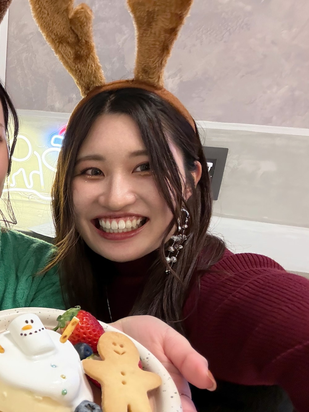 レッド系のニット/セーター、ブラック系のスカート、ホワイト系のスリッポンを着用したレディースの冬コーディネートの4枚目の写真