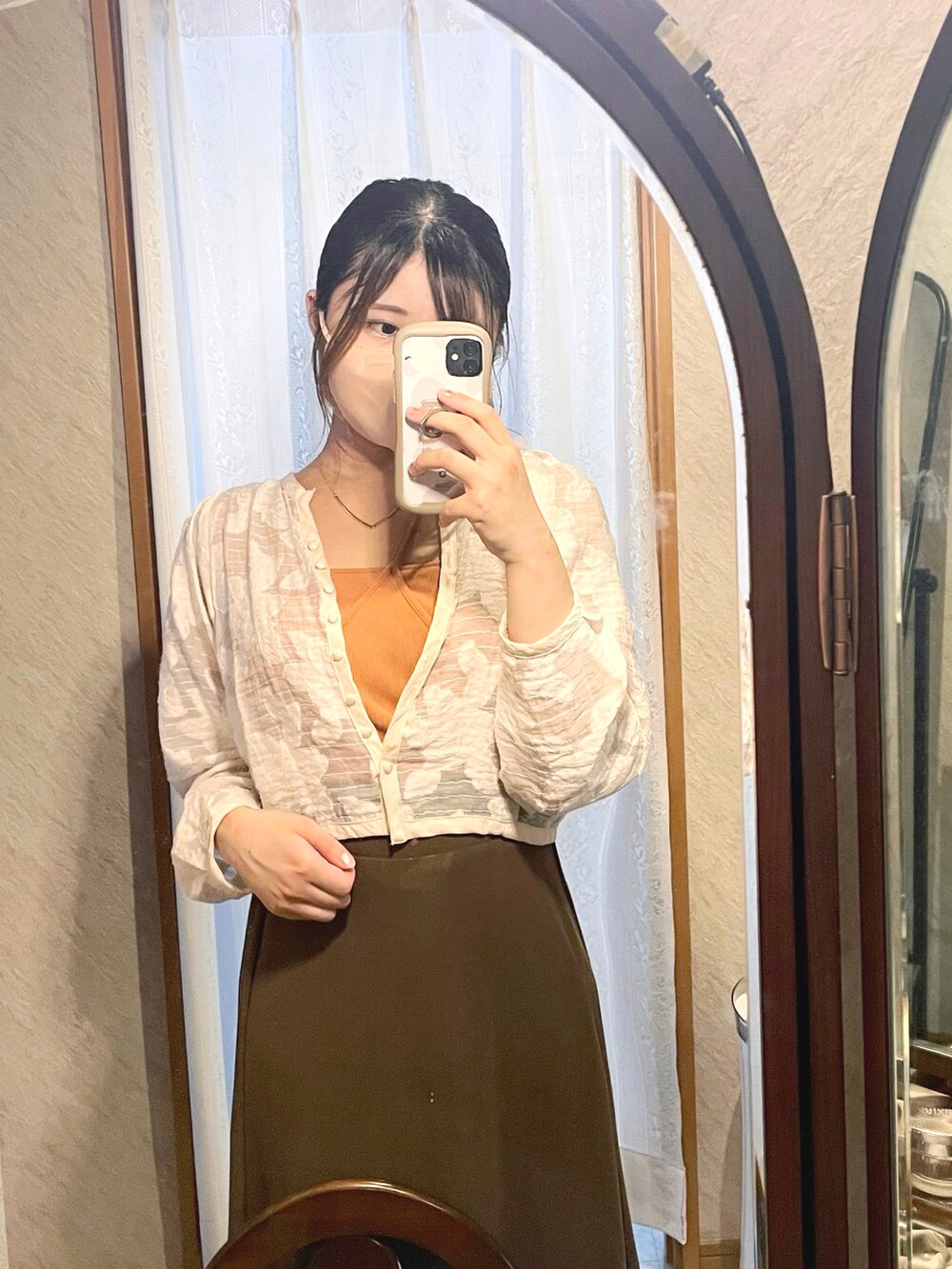 ホワイト系のノーカラージャケット、オレンジ系のキャミソール、ブラウン系のスカートを着用したレディースの秋コーディネートの2枚目の写真