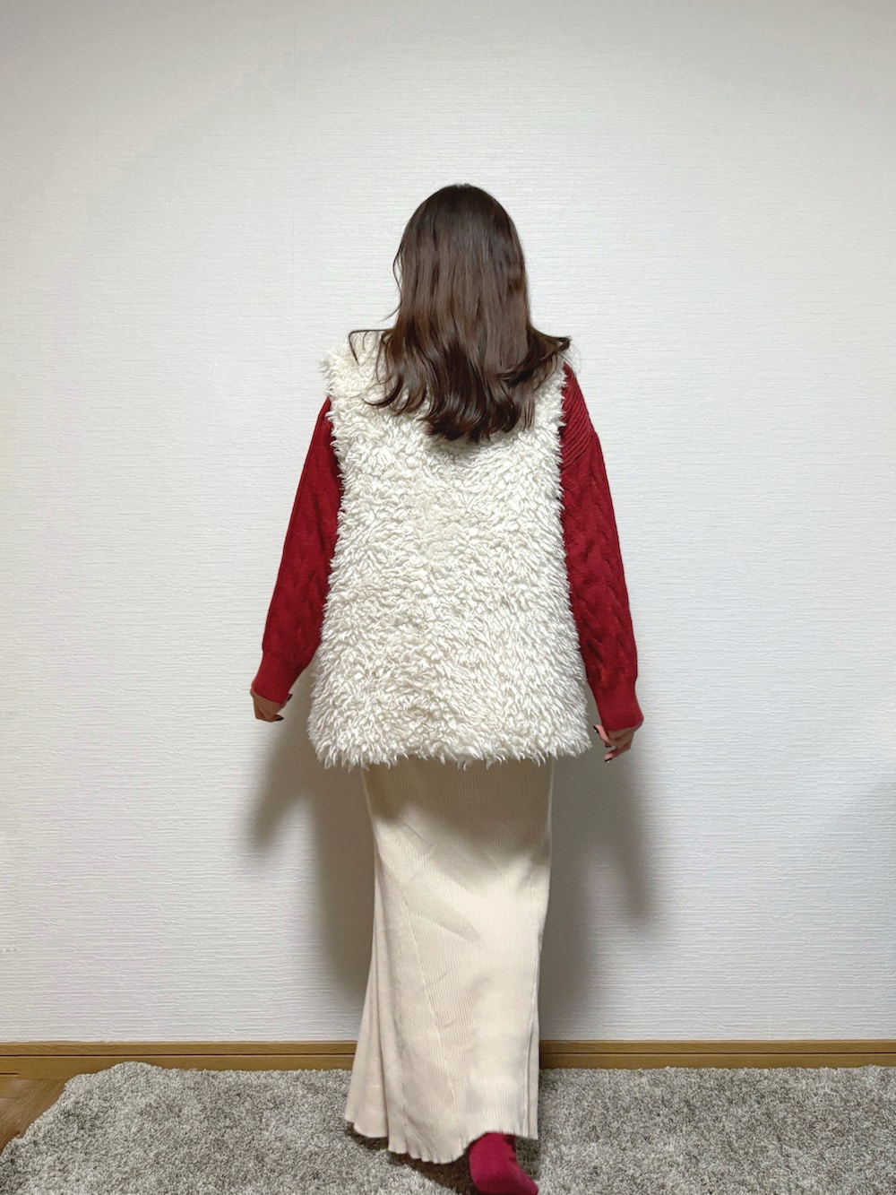 ホワイト系のベスト、ベージュ系のスカートを着用したレディースの冬コーディネートの4枚目の写真