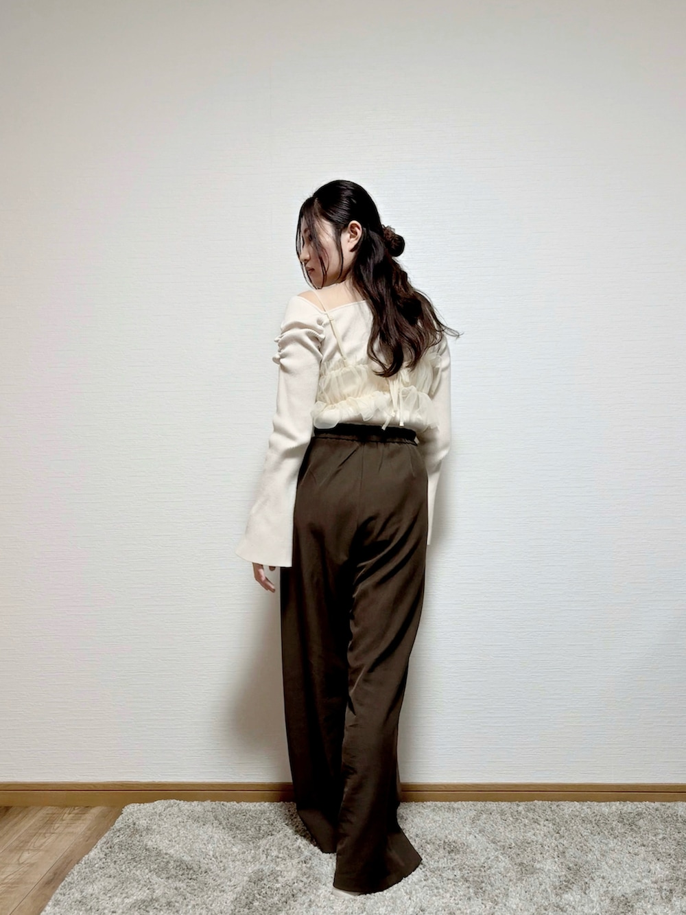 ベージュ系のキャミソール、ホワイト系のニット/セーター、ブラウン系のパンツを着用したレディースの春コーディネートの2枚目の写真