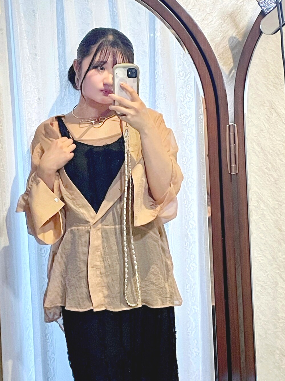 オレンジ系のシャツ/ブラウス、ブラック系のワンピース、ベージュ系のキャミソールを着用したレディースの春コーディネートの3枚目の写真