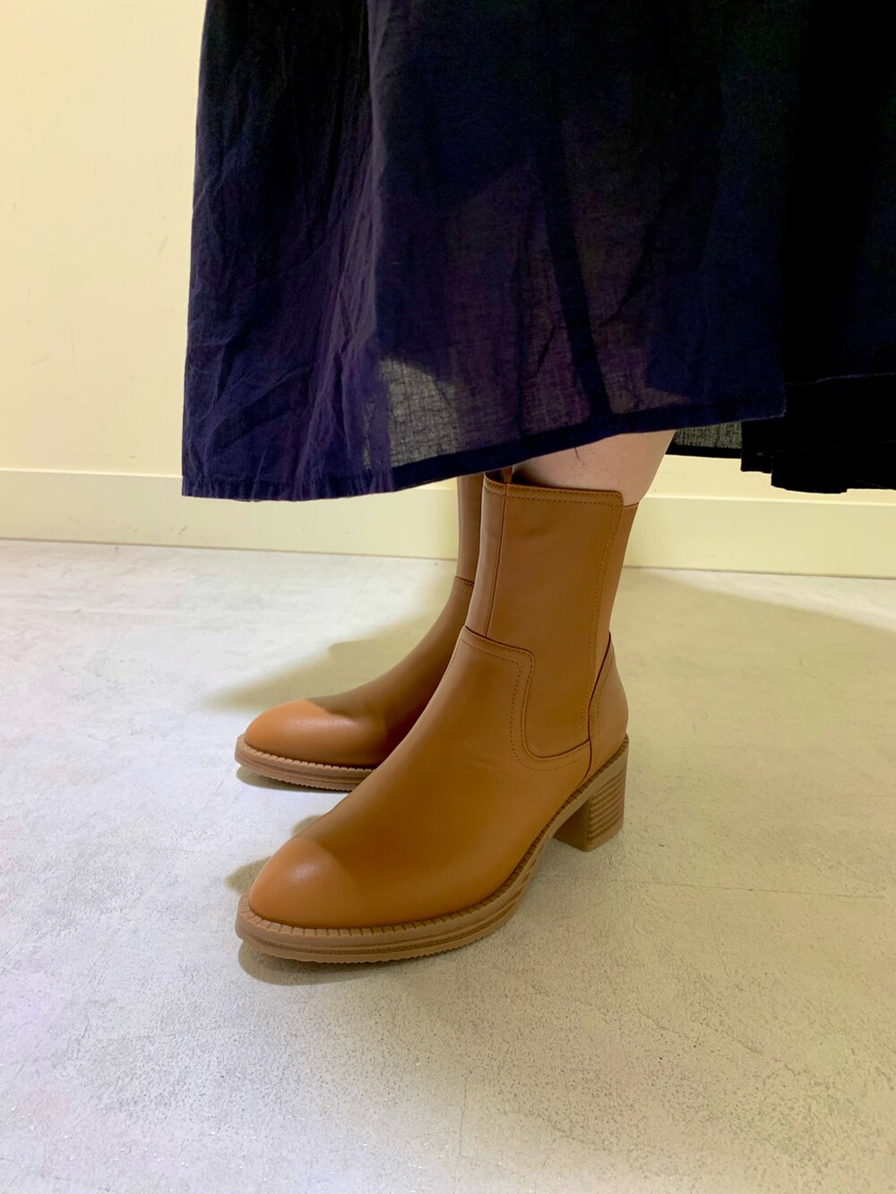 ブラウン系のブーツを着用したレディースの秋コーディネートの2枚目の写真