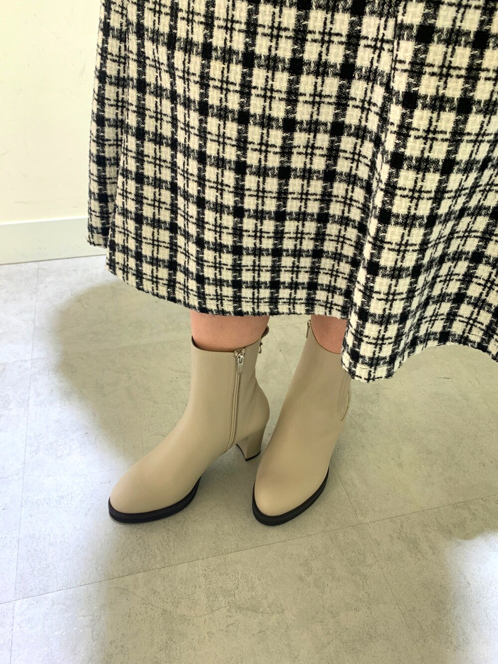 ホワイト系のブーツを着用したレディースの秋コーディネートの2枚目の写真