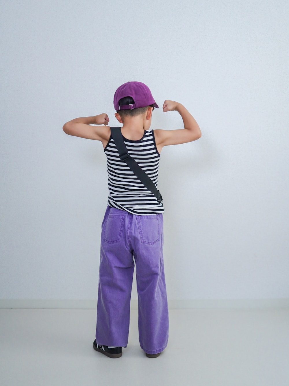 パープル系のその他パンツ、ブラック系のスニーカー、ブラック系のタンクトップを着用したキッズの夏コーディネートの3枚目の写真