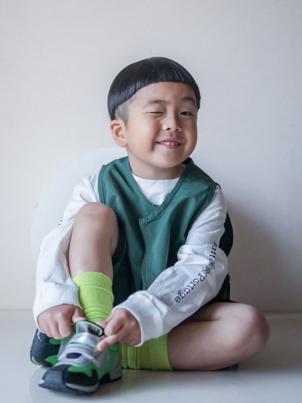 グリーン系のベスト、ブラック系のその他パンツ、グリーン系のシューズを着用したキッズの春コーディネートの3枚目の写真